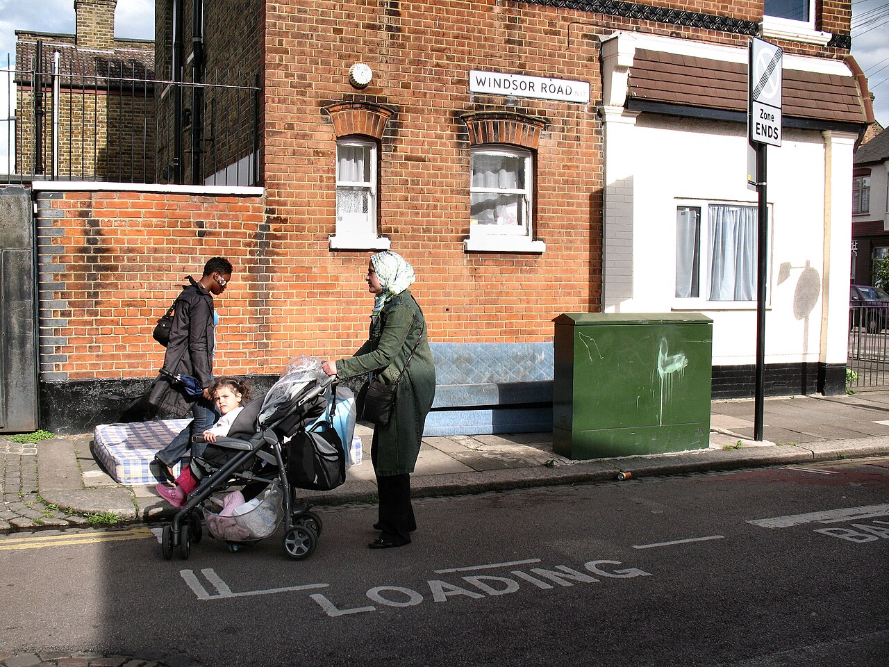 A double mattress dumped against a garden wall on a London street corner