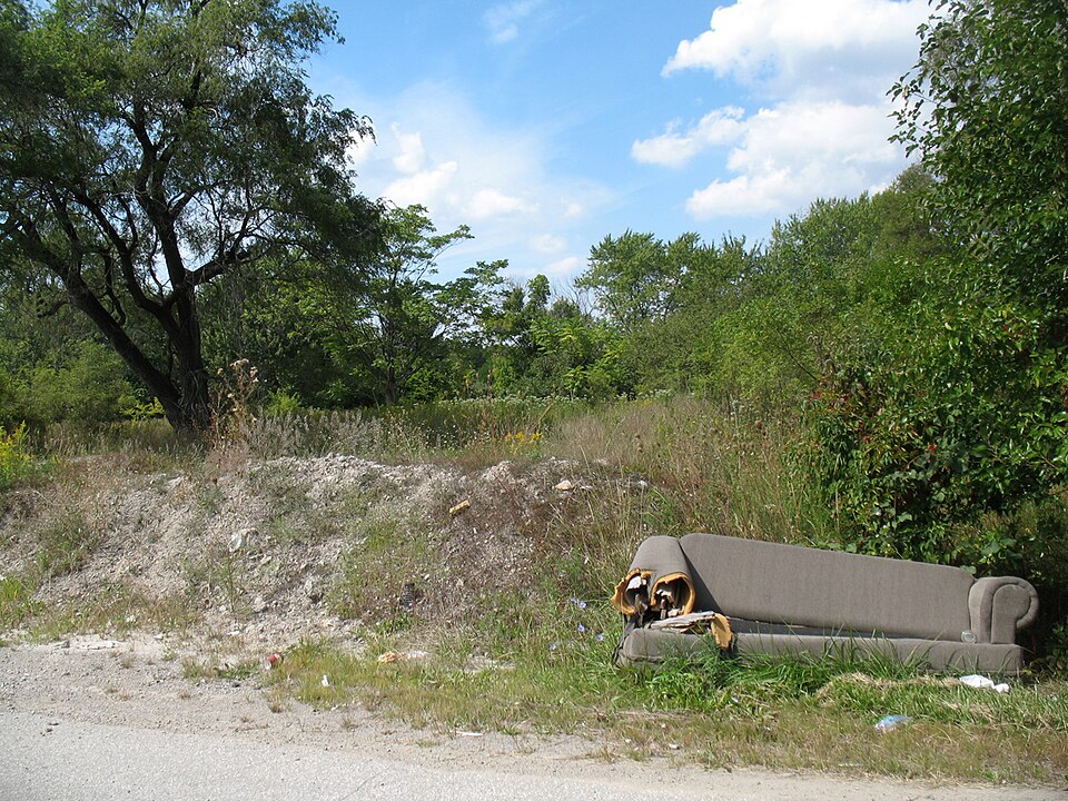 A worn-out sofa dumped at the roadside, waiting for someone to deal with it